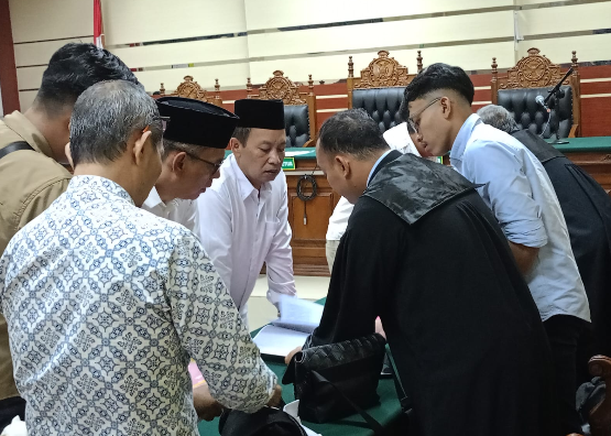 Tiga terdakwa, pengurus PKD Kabupaten Kediri, setelah mendengar tuntutan jaksa, bermusyawarah dengan masing masing penasehat hukumnya.